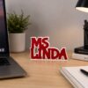 Forjolie red Ms Linda name sign displayed on a desk with a laptop
