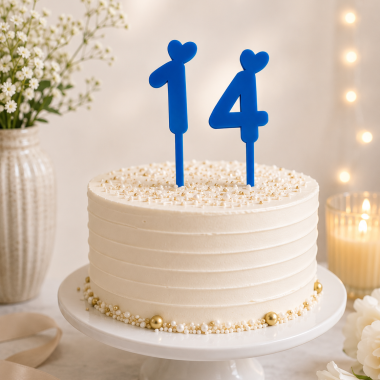Personalized number birthday cake topper with blue accents on a decorated cake.