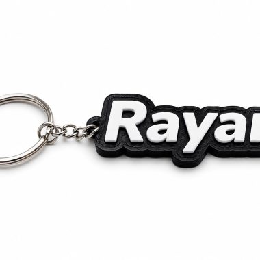 Personalized name keychain with "Raya" in white lettering on a black background, Forjolie Dubai keepsake.