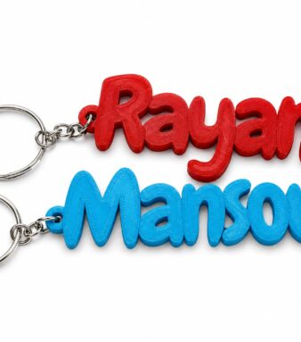 Personalized bubble name keychain with "Rayan Mansour" in red and blue 3D printed plastic.