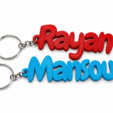 Personalized bold name keychain with red and blue 3D printed lettering, Dubai souvenir.