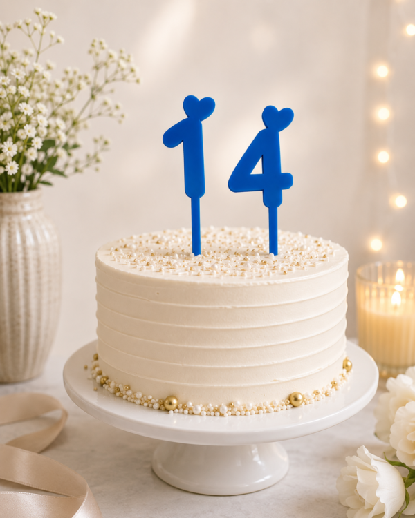 Blue number 14 cake topper with heart detail on a birthday cake