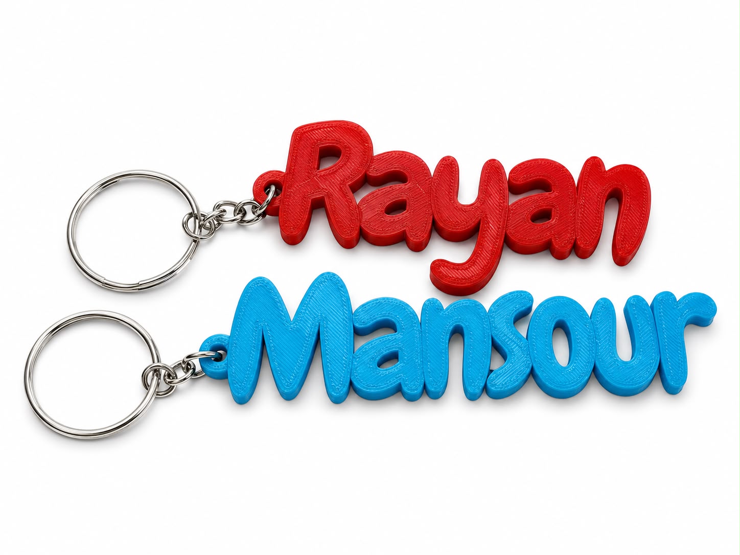 Personalized bubble name keychain with "Rayan" and "Mansour" in red and blue, 3D printed in