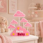 Forjolie pink Hello Baby cloud decor displayed in a nursery with stuffed animals