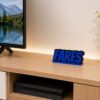 Forjolie blue personalized Fares name sign displayed on a TV console shelf